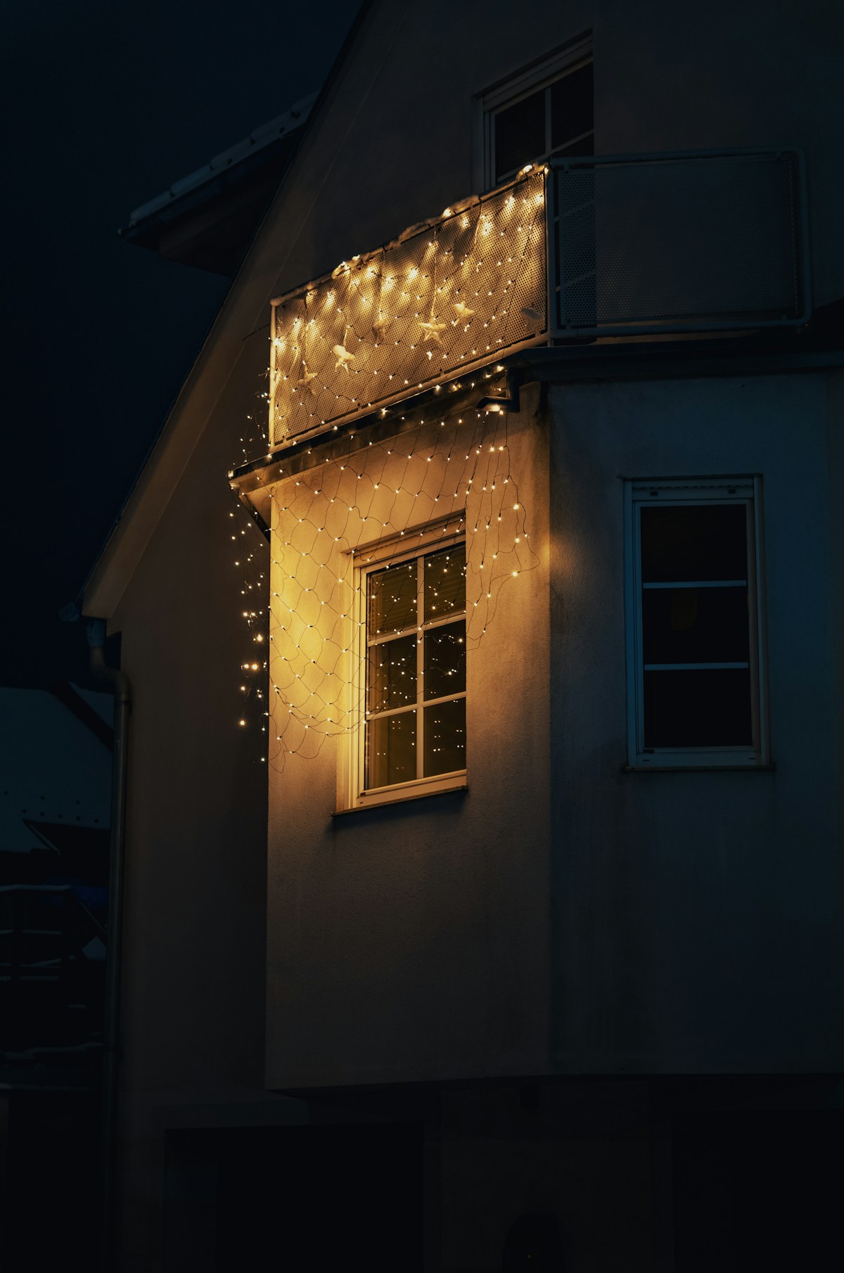 Warm white string lights decorating a home at night
